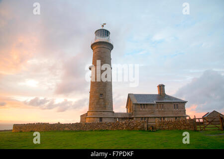 Lundy Old Light, retired lighthouse under a colourful sunset, the sky's colours refelcting on the slate roof Stock Photo