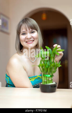 Girl with lucky bamboo plant at her home Stock Photo