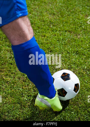 soccer player doing kick with ball on football stadium  field  isolated on black background Stock Photo