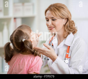 Pediatrician doctor examining kid's throat Stock Photo