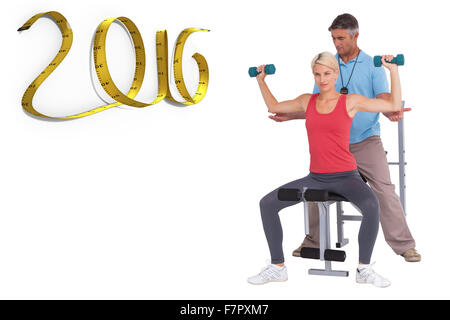 Composite image of trainer helping client lift weights Stock Photo
