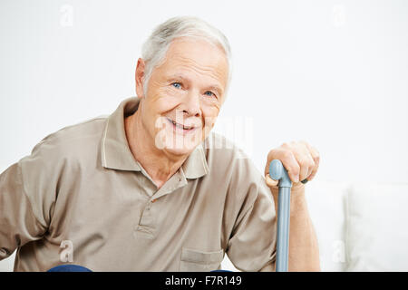Old smiling senior man with his hand on a cane Stock Photo