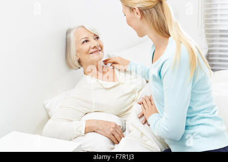 Young woman helping senior woman with her personal hygiene