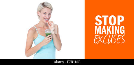 Composite image of beautiful woman drinking green juice Stock Photo