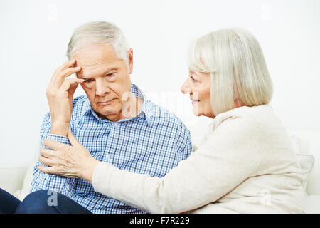 Old woman comforting senior man with depression at home Stock Photo