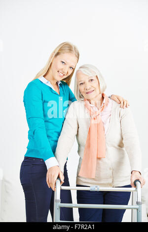 Granddaughter helping old senior woman at home Stock Photo