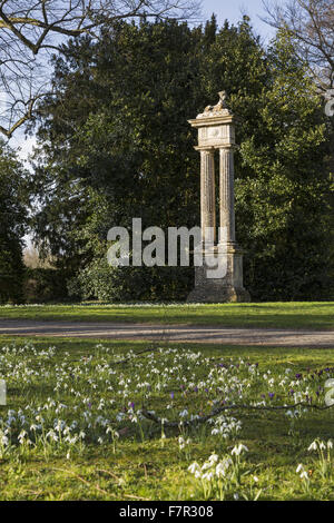 A view of the stone sphinx by Benjamin Carter, standing on fluted columns in the grounds of Lacock Abbey, Wiltshire, with snowdrops in bloom in the foreground. Stock Photo