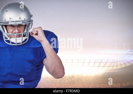 Composite image of american football player standing on one leg while holding ball Stock Photo