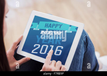 Composite image of teen using a tablet pc sitting on the floor Stock Photo