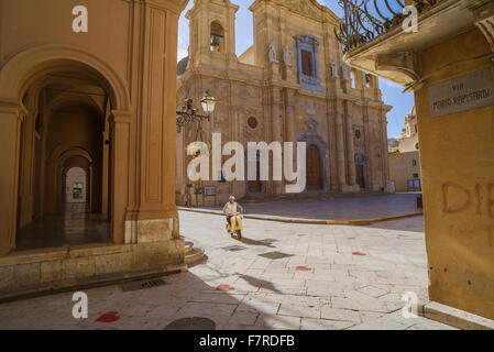 Baroque Sicily, view of a Sicilian man riding his scooter through the Baroque environment of the Piazza della Repubblica in Marsala, Sicily. Stock Photo