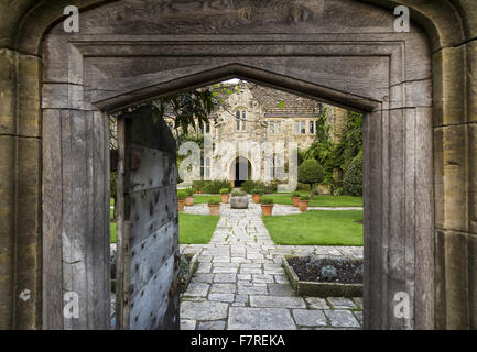 View through an open door to the walled Forecourt garden and exterior of the house at Nymans, West Sussex, in October. Stock Photo