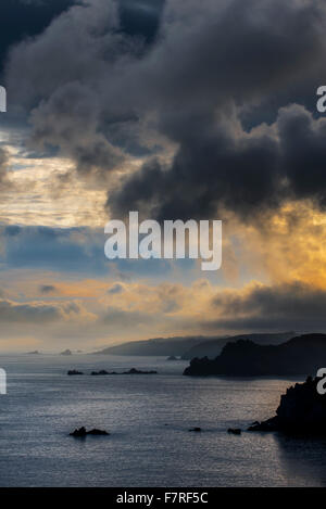 Sea cliffs at the Pointe de Penharn at sunrise with storm clouds, Cléden-Cap-Sizun, Finistère, Brittany, France Stock Photo