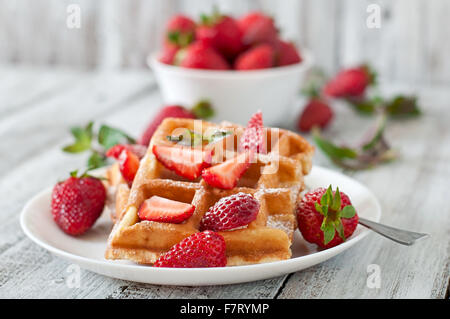 Belgium waffles with strawberries and mint on white plate. Stock Photo