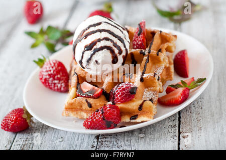 Belgium waffles with strawberries and ice cream on white plate. Stock Photo