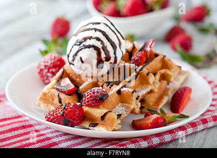 Belgium waffles with strawberries and ice cream on white plate. Stock Photo