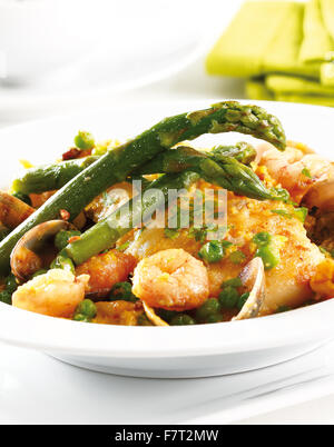 Hake fish served with asparagus on a white table Stock Photo