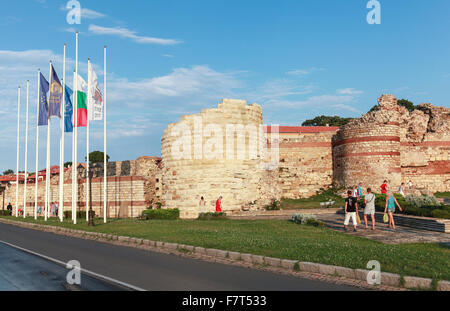Nesebar, Bulgaria - July 20, 2014: Tourists walking near the Ruined tower and stone walls around the old Nessebar town Stock Photo