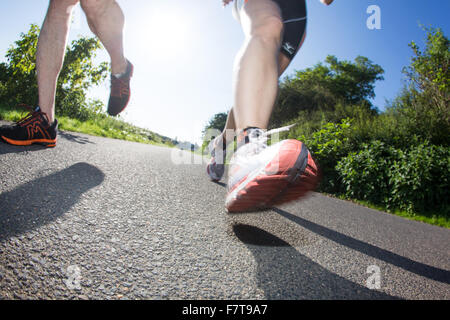 Legs, jogging shoes, joggers on asphalt track, Germany Stock Photo
