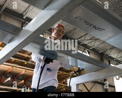 Worker welding metal frames in HVAC manufacturing factory. Stock Photo