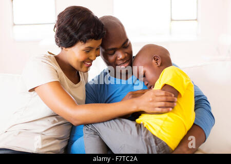 loving young African couple comforting their ill son at home Stock Photo