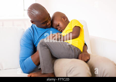African American father comforting his ill son at home Stock Photo