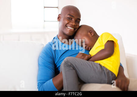 loving father sitting on the couch with his cute son Stock Photo
