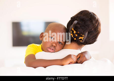 rear view of African woman holding her adorable son at home Stock Photo