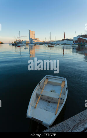 A small rowboat with the Cameco Fuel Manufacturing Inc. factory in the background at the Port Hope Harbour. Port Hope, Ontario. Stock Photo