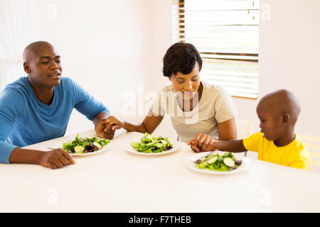 young African family praying before having meal at home Stock Photo