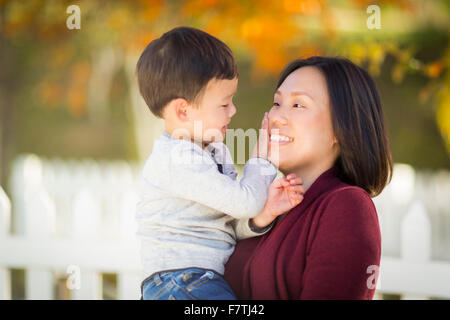 Happy Chinese Mom Having Fun and Holding Her Mixed Race Little Boy. Stock Photo