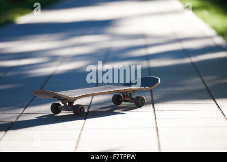 Old used skateboard isolated on the ground on street Stock Photo