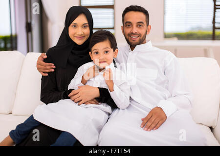 happy Muslim family sitting on the couch at home Stock Photo