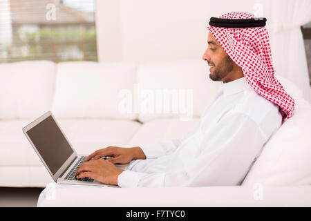 young Muslim man using laptop at home Stock Photo