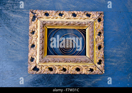 Golden ornate antique art frame with clock  spiral on black background Stock Photo