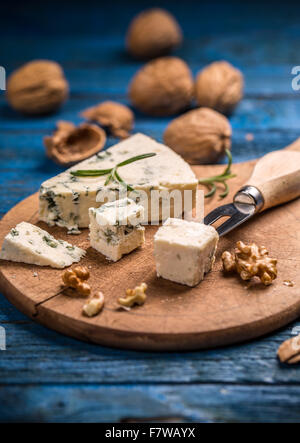 Blue cheese with nuts on cutting board Stock Photo