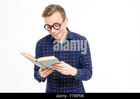 Funny cheerful smart blond man in in plaid shirt and round glasses reading a book and smiling over white background Stock Photo