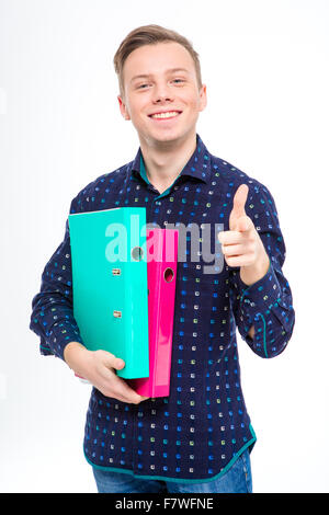 Confident positive young manin checkered shirt holding colorful folders and pointing on you over white background Stock Photo