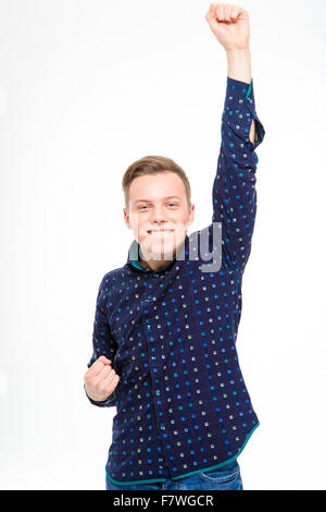 Exited cheerful successful man in plaid shirt  raised hand up gesturing victory over white background Stock Photo