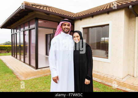 portrait of lovely young Muslim couple standing in front of their house Stock Photo