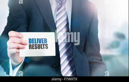 Businessman holding a card with Deliver Results written on it. Stock Photo