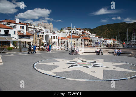 Small square in Marmaris Turkey with mosaic compass and holiday makers tourists adjacent to the Marina Stock Photo
