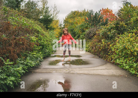 Girl jumping in a puddle Stock Photo