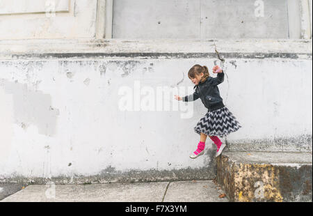Girl jumping off a step Stock Photo