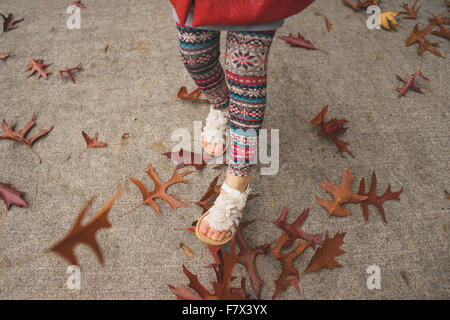 Girl skipping along a path in autumn Stock Photo