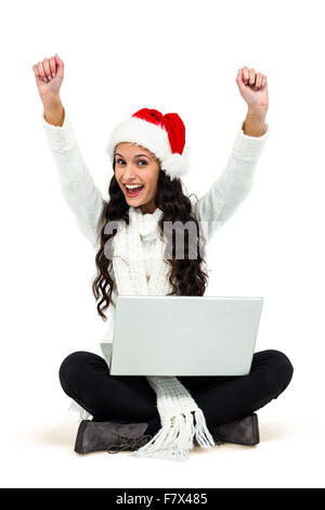 Woman sitting on the floor rejoicing looking at laptop Stock Photo