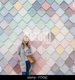 Woman standing next to a colorful wall Stock Photo