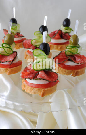Canape of the baguette with salami on a glass base Stock Photo