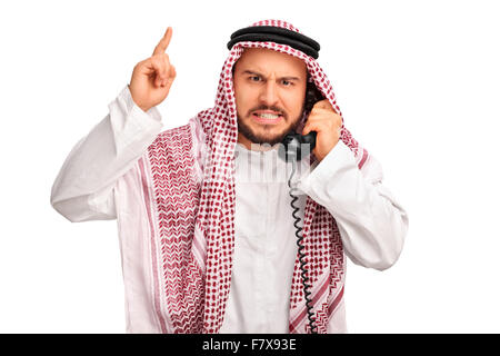 Studio shot of an angry Arab talking on telephone and threatening with his finger isolated on white background Stock Photo