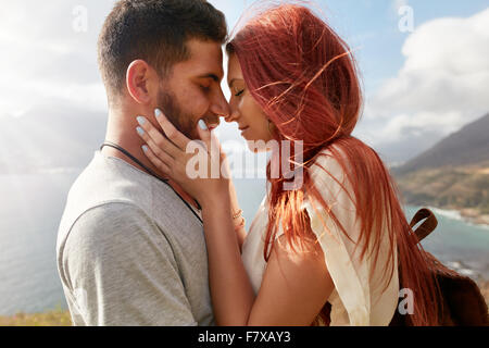 Portrait of affectionate young couple about to kiss. Romantic young man and woman sharing a lovely moment on their summer vacati Stock Photo