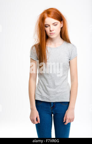 Portrait of sad exhausted young redhead girl with long tousled hair isolated over white background Stock Photo